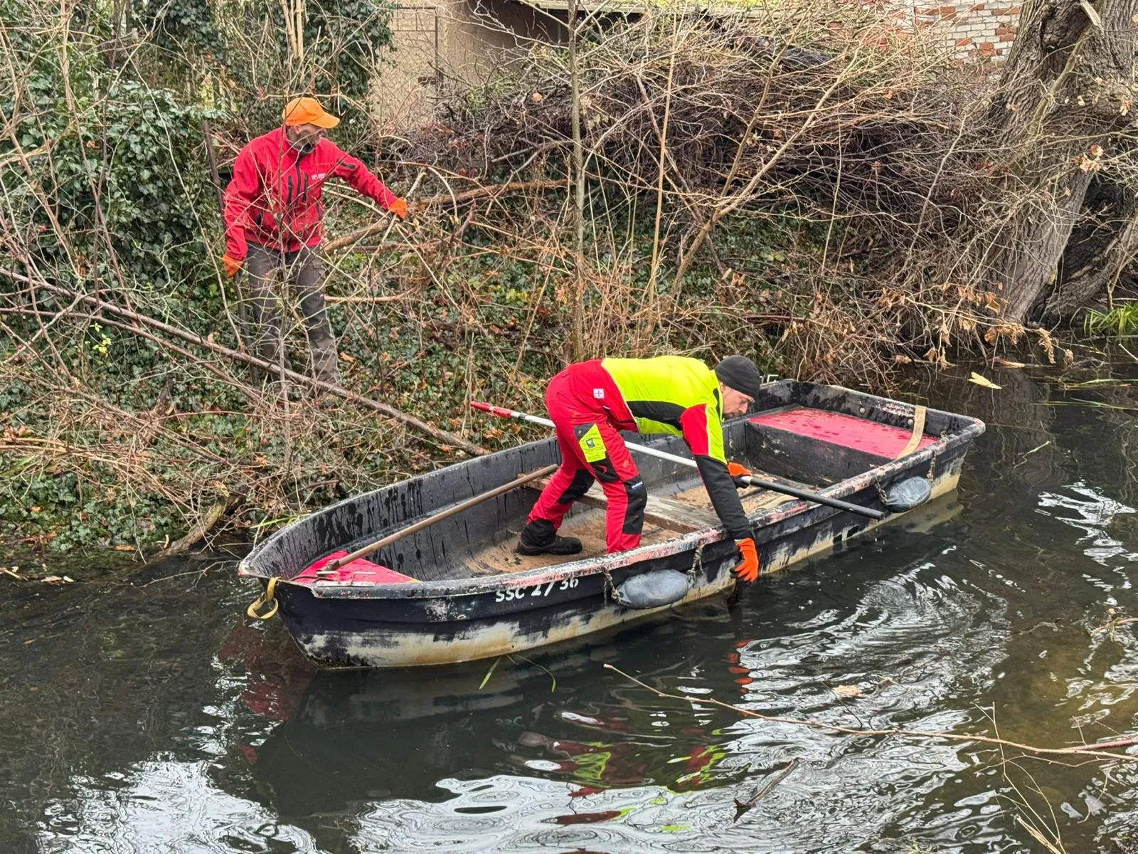 Arbeiten vom Boot aus im Wassergraben
